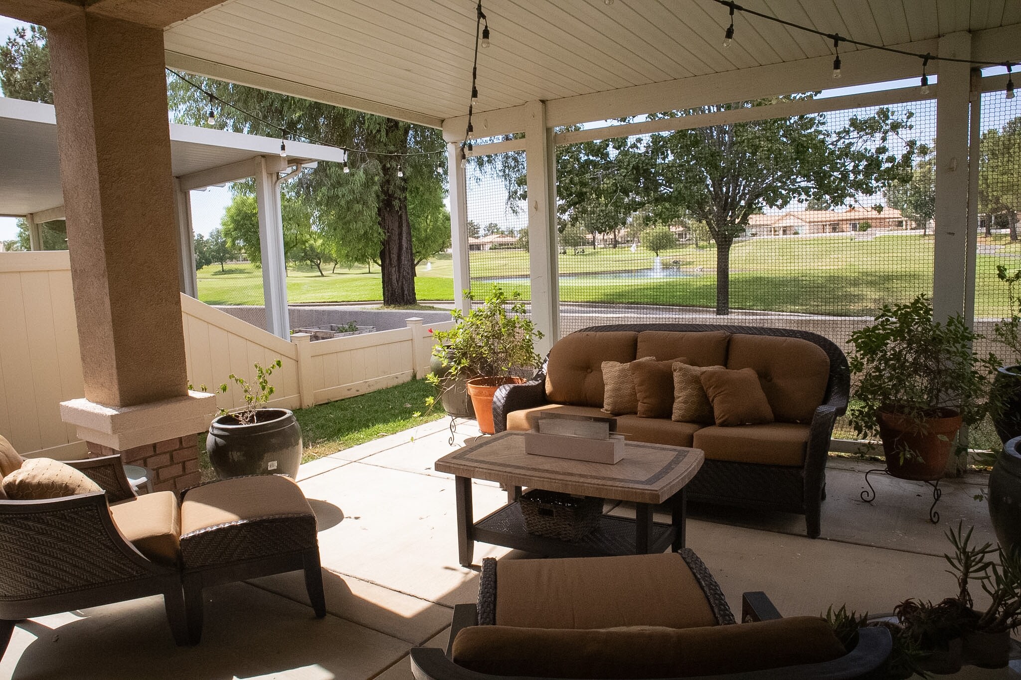 Covered patio overlooking the landscaped yard and golf course